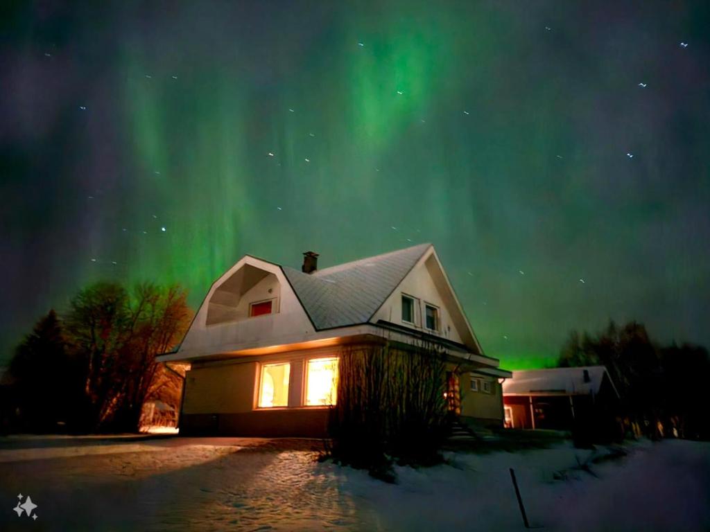 una casa con la aurora en el cielo en Authentic Arctic Villa at the Delta, en Rovaniemi