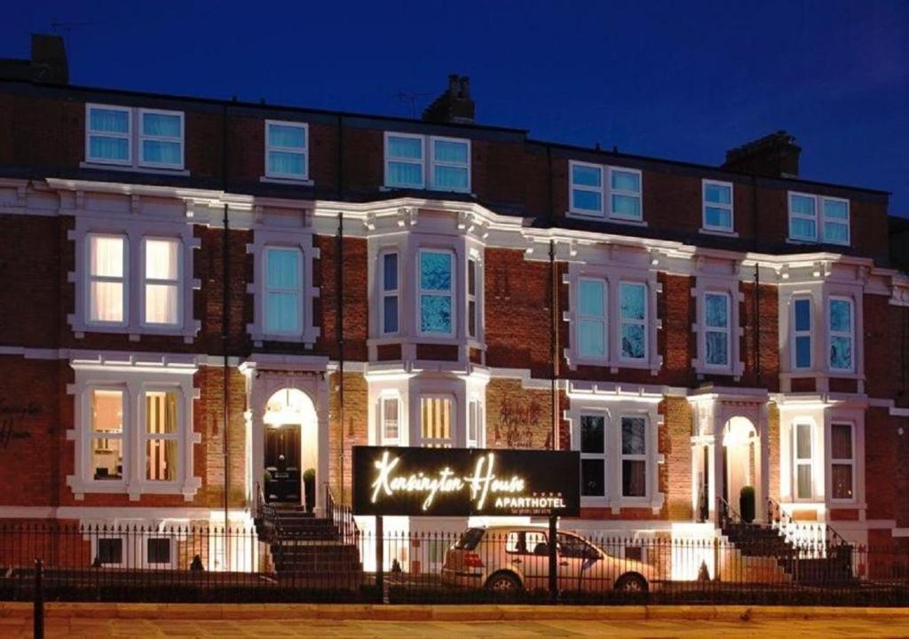 a large brick building with a sign in front of it at Kensington House by Warren Collection in Newcastle upon Tyne