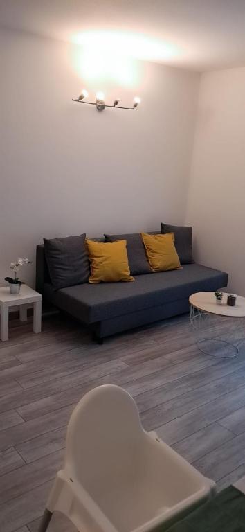 - un salon avec un canapé bleu et deux oreillers jaunes dans l'établissement GabiHome, à Mulhouse