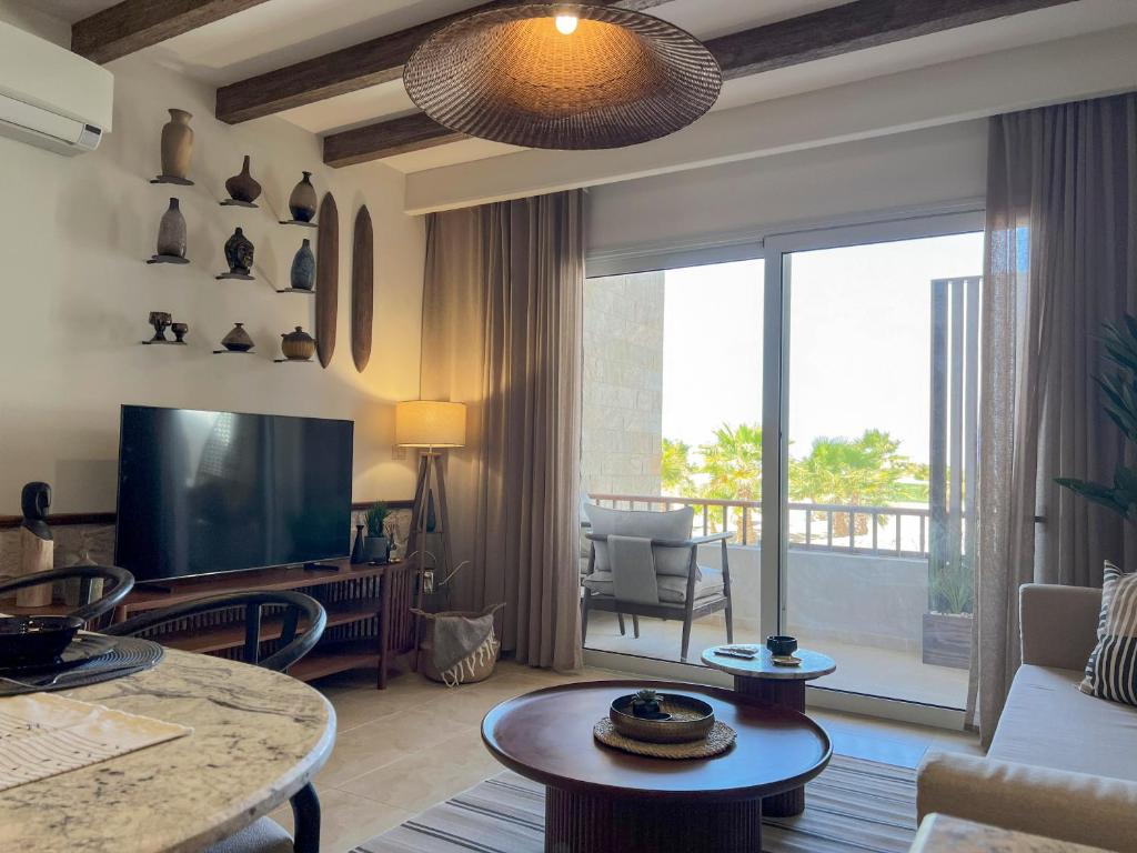 ハルガダにあるCasa De Madera - 1BR Sea & Golf View - Soma Bayのリビングルーム(テレビ、大きな窓付)