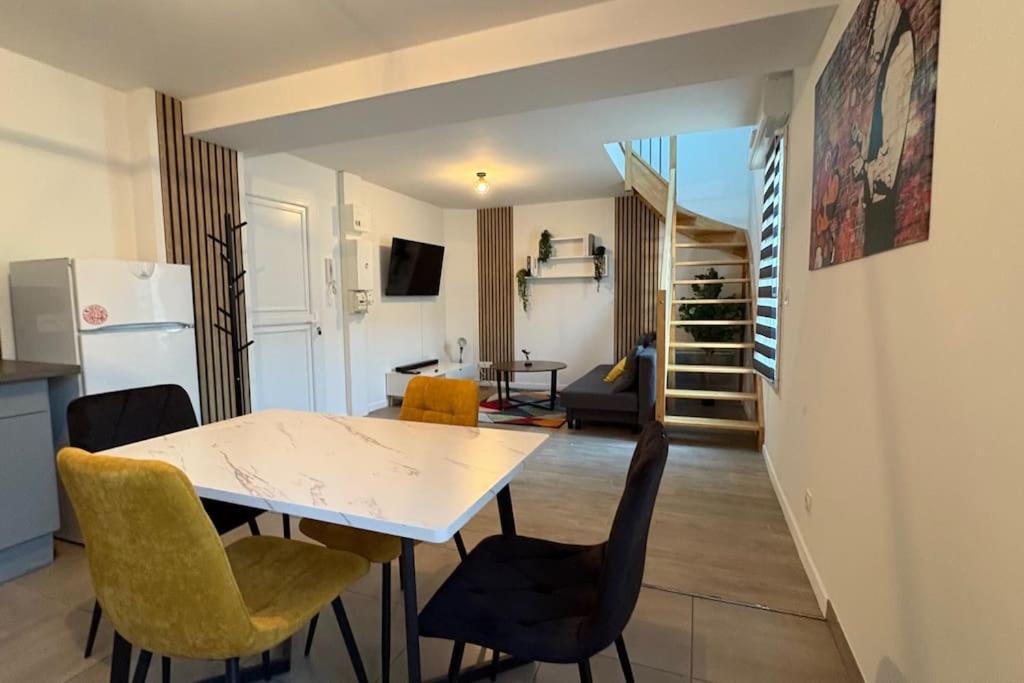 une cuisine et un salon avec une table et des chaises dans l'établissement Guangzhou - Duplex agréable, à Reims