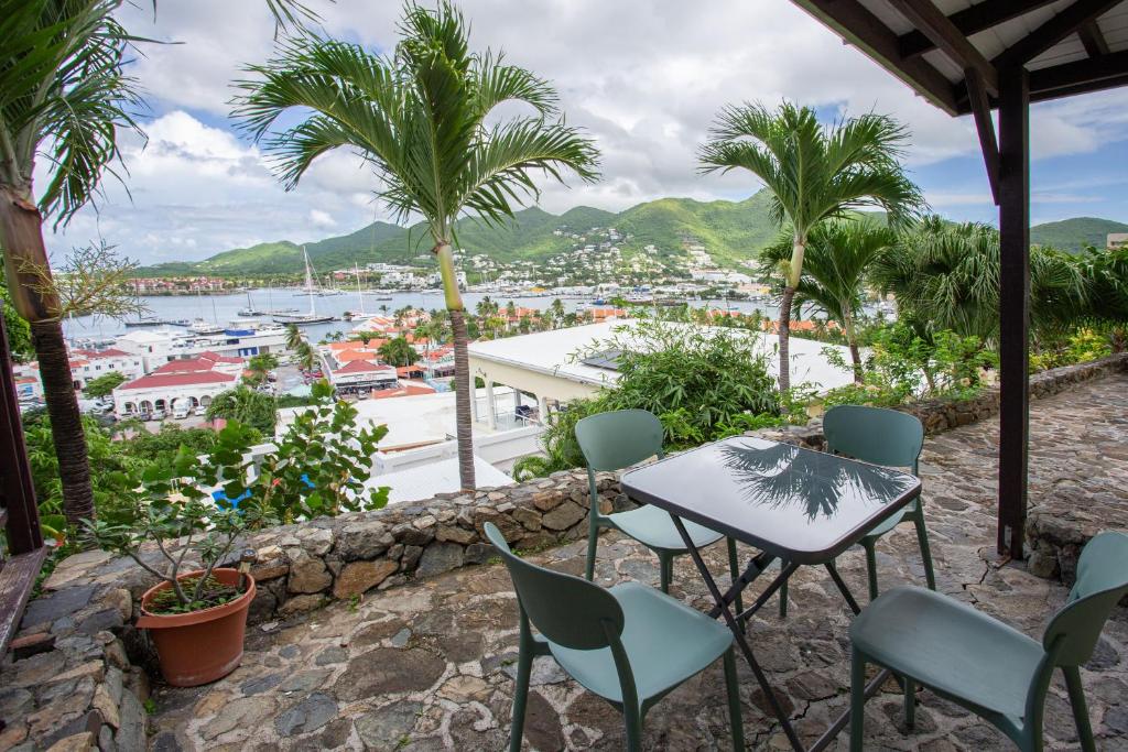 a table and chairs on a balcony with a view of a harbor at Cozy Cottage 1 bedroom with Stunning Views in Simpson Bay