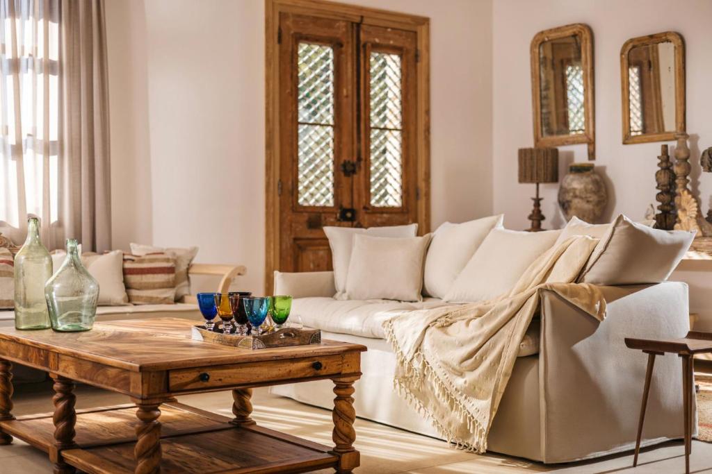 un soggiorno con un divano bianco e un tavolo di Le tresor de Marie - Charming Traditional Retreat, by ZanteWize a Gaïtánion