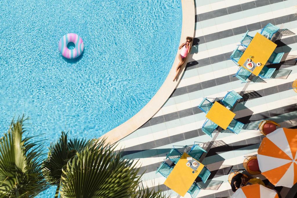 una vista panoramica su una piscina con ombrelloni e piscina di tent Mojito Suites a Magaluf