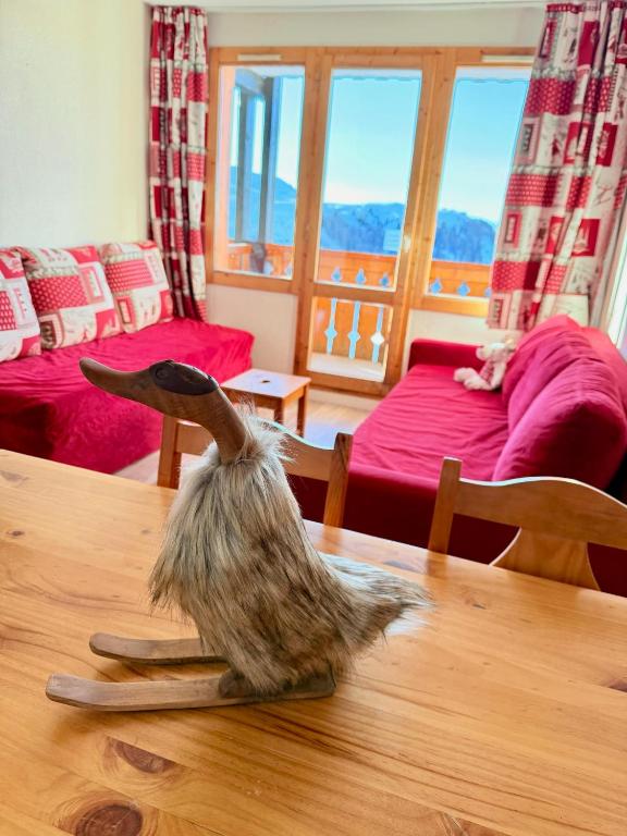 un chat assis sur une table dans un salon dans l'établissement Résidence Licorne BELLE PLAGNE, à La Plagne Tarentaise