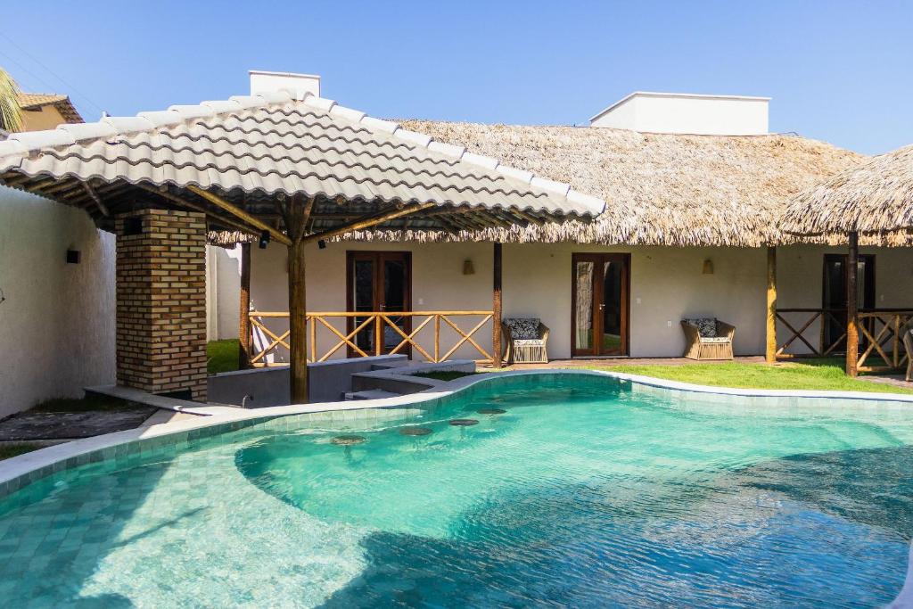 a swimming pool in front of a house at Villaggio Di Mare - até 28 pessoas in Luis Correia