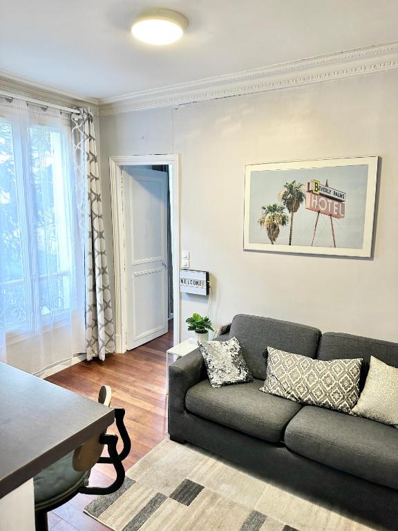 un salon avec un canapé et une table dans l'établissement Appart cosy à 15 min des Champs-Elysées, à Levallois-Perret