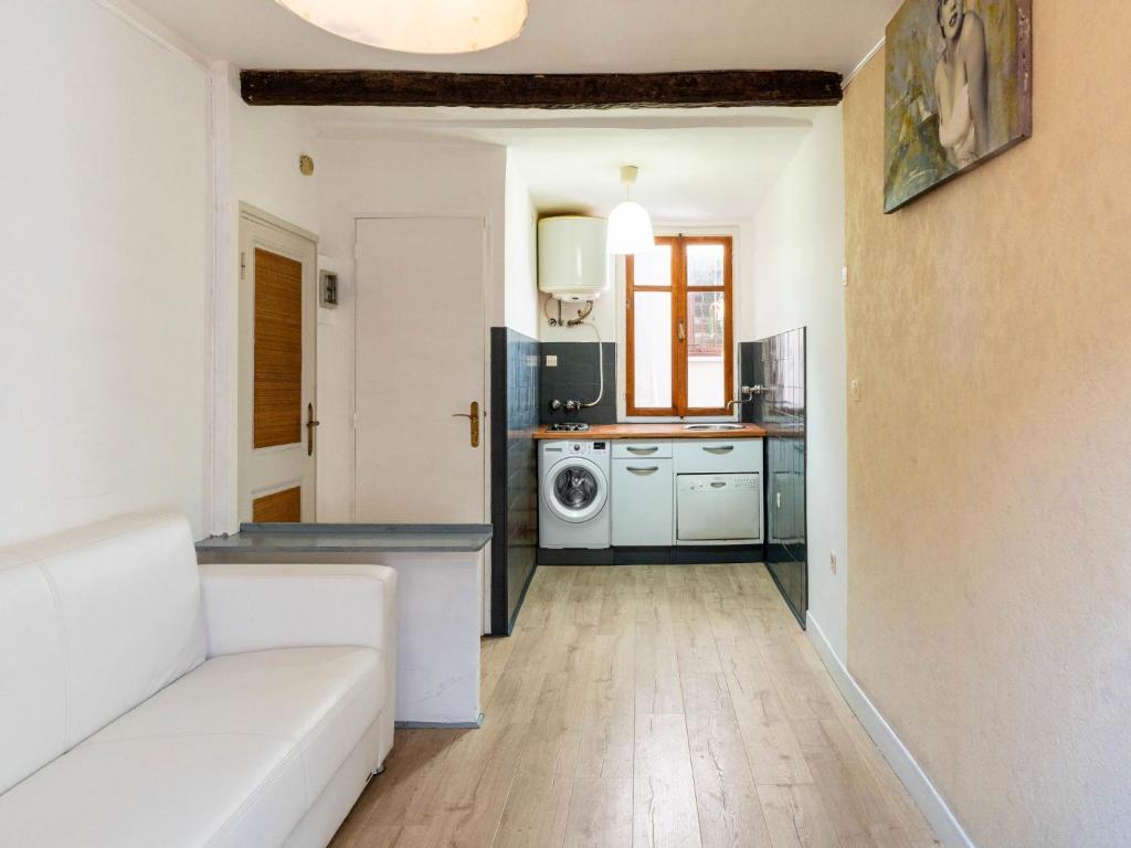 a living room with a white couch and a kitchen at Apartment The Nest by Interhome in Ventimiglia