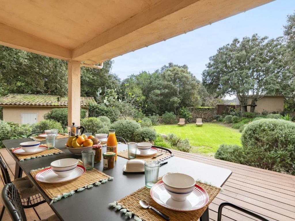 une table à manger extérieure avec vue sur le jardin dans l'établissement Holiday Home Villa Les Chênes by Interhome, à Porto-Vecchio