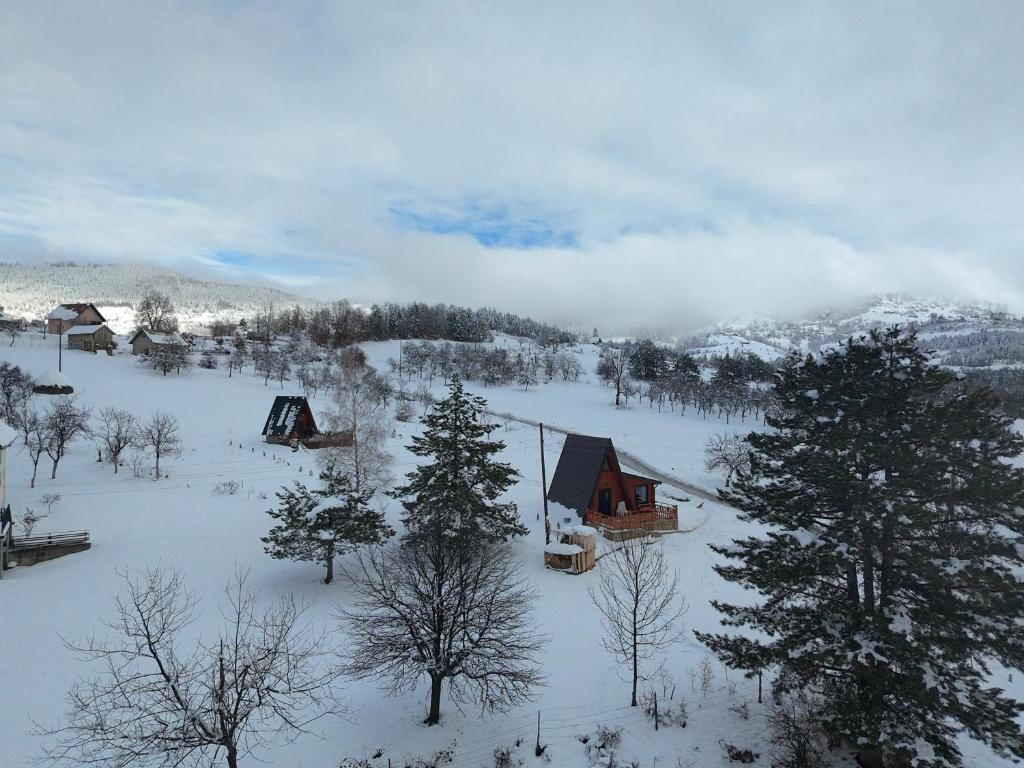 a cabin in the snow with trees and mountains at A Pine vikendica u srcu Zapadne Srbije in Nova Varoš