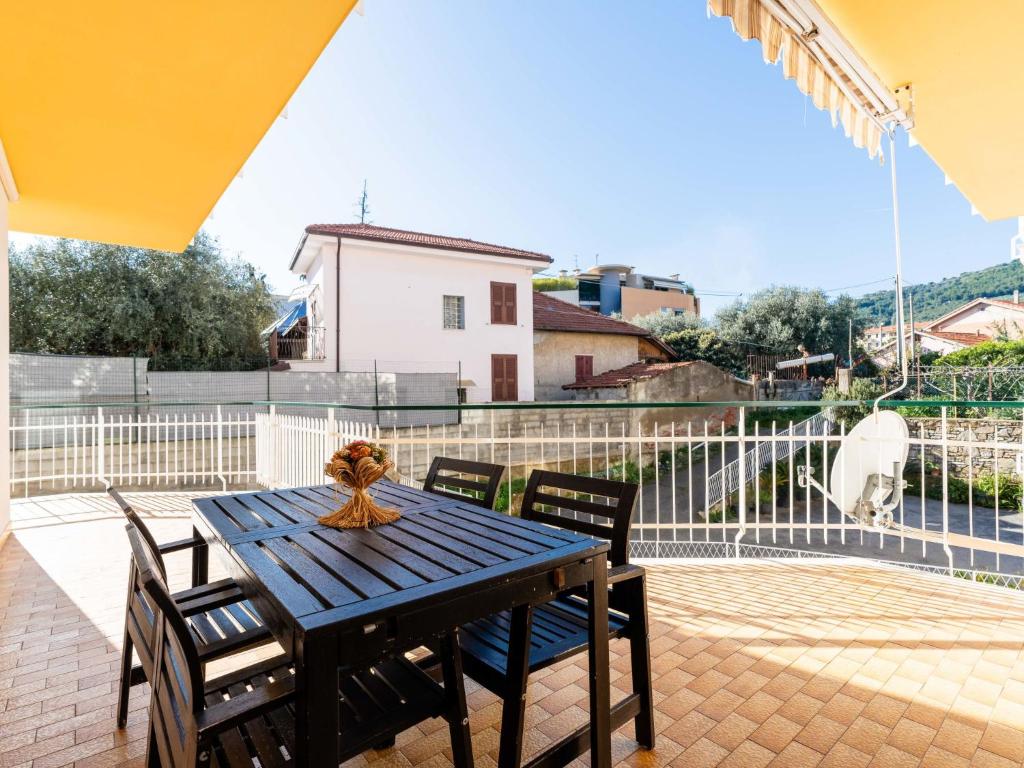 a wooden table and chairs on a patio at Apartment le Mimose by Interhome in Taggia