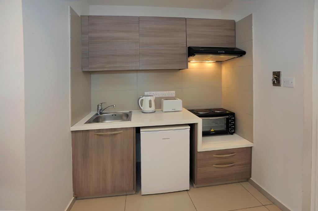 a small kitchen with a sink and a microwave at Euronapa Hotel Apartments in Ayia Napa