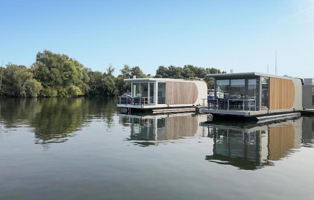 dos casas en un muelle sobre un cuerpo de agua en House Boat Tenerife, en Maastricht
