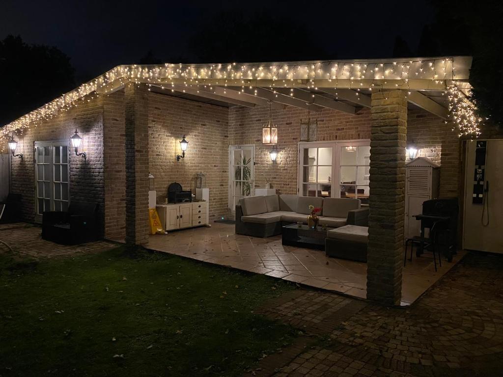 a pergola with lights on a patio at night at Bungalow between Amsterdam and Haarlem with sauna in Vijfhuizen