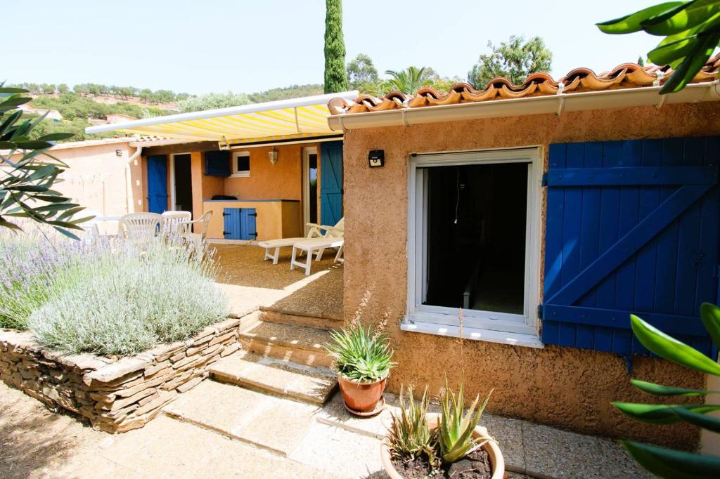 une maison avec une porte bleue et quelques plantes dans l'établissement Mazet Mireille climatisé pour 4 personnes avec tennis et piscine à La Londes-Les-Maures, à La Londe-les-Maures