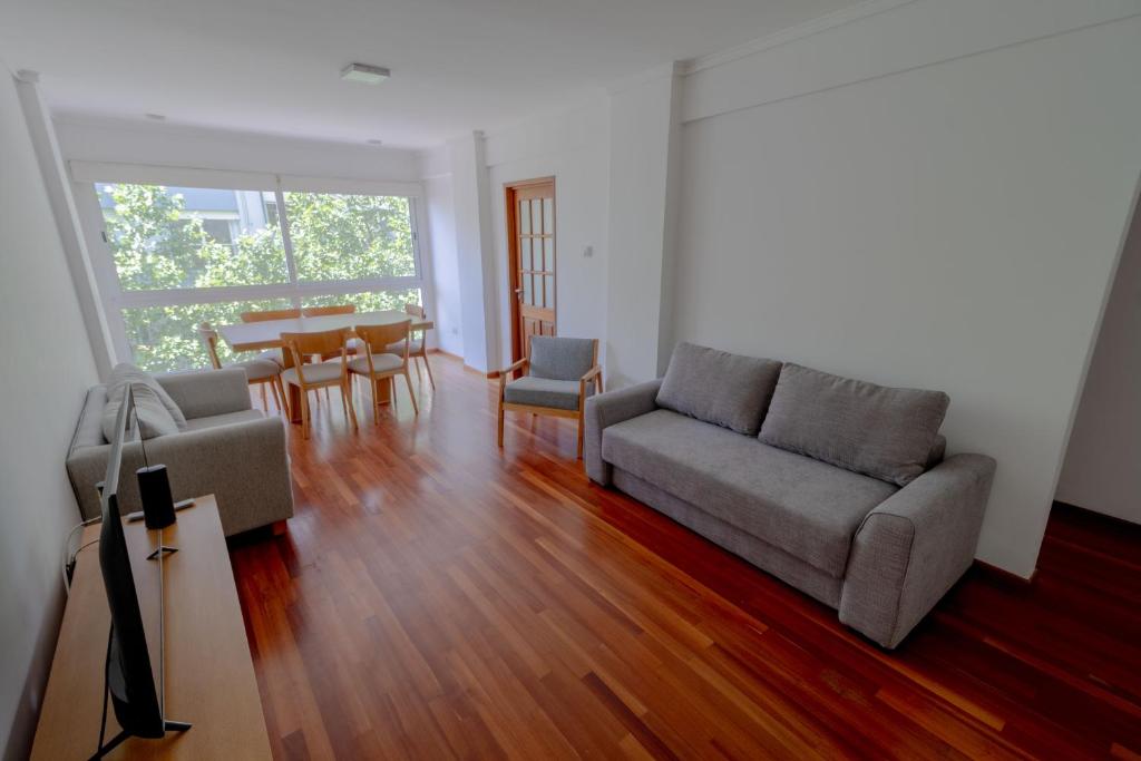 un soggiorno con un divano e un tavolo di Check and Home - Córdoba - Departamento Moderno en el Centro al Frente con Cochera a Mar del Plata