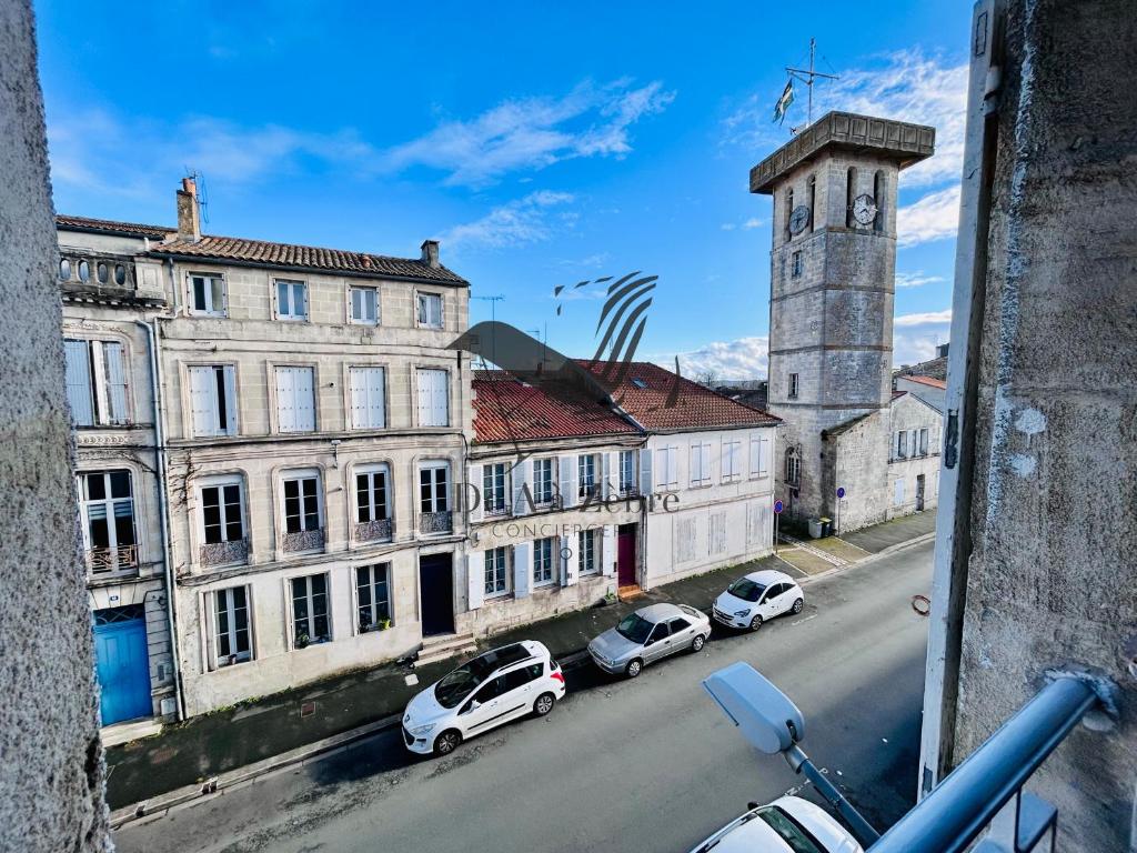 - une vue sur une rue avec des voitures garées devant les bâtiments dans l'établissement L'Albatros - Situé en plein coeur de ville, à Rochefort