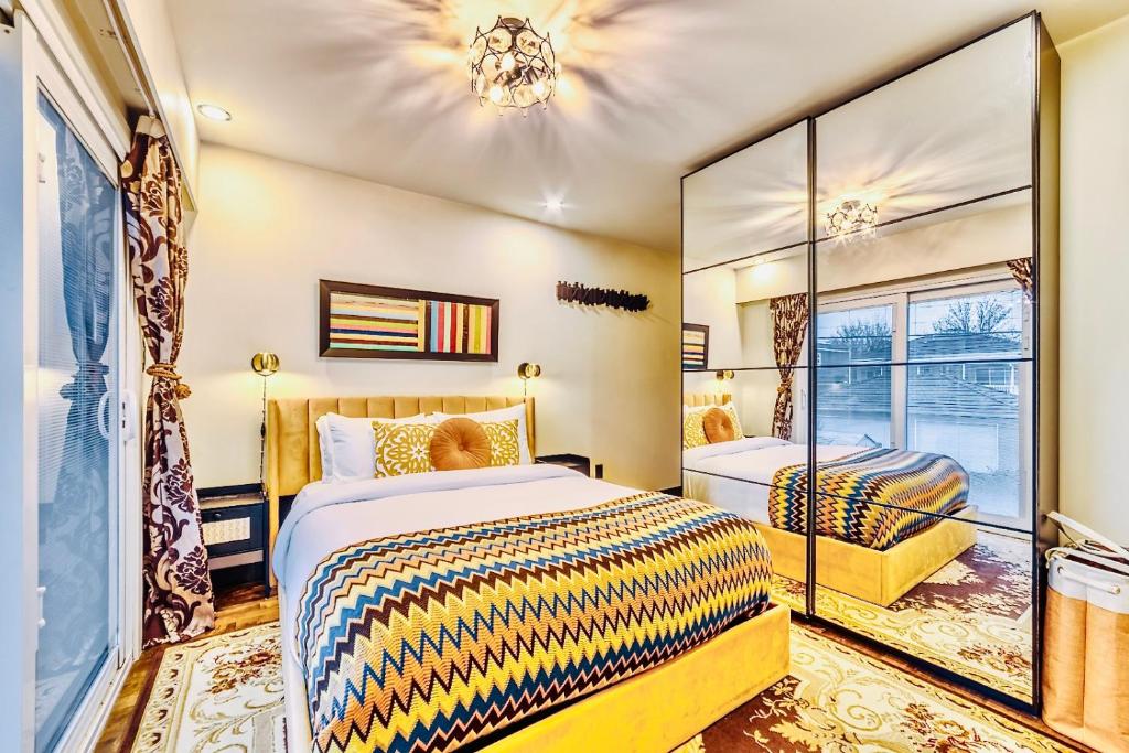 a bedroom with two beds and a mirror at Neocolonial Nouveau Kensington Vacation Home in Vancouver