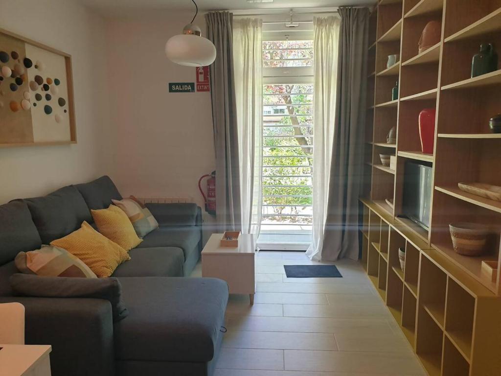 a living room with a couch and a window at Piso con garaje junto a Ifema in Madrid