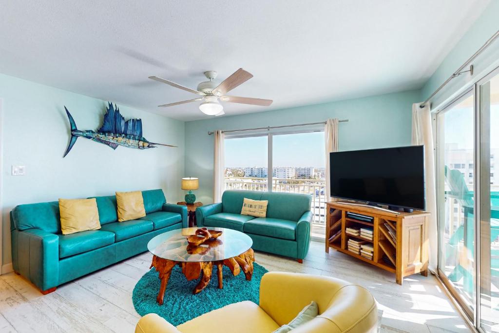 a living room with a couch and a tv at Anglers Cove 602 in St. Pete Beach