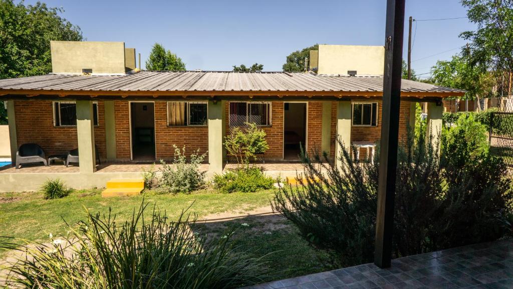 a house with a metal roof in a yard at Monoambiente amplio con pileta in Cosquín
