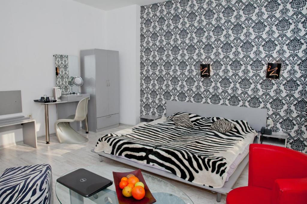 a bedroom with a bed and a red chair at Scotty's Boutique Hotel in Sofia