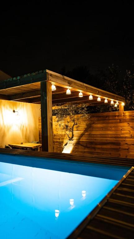 une piscine la nuit avec des lumières sur le dessus dans l'établissement Suite l'Olive Sacrée Spa et Sauna, à Cabannes