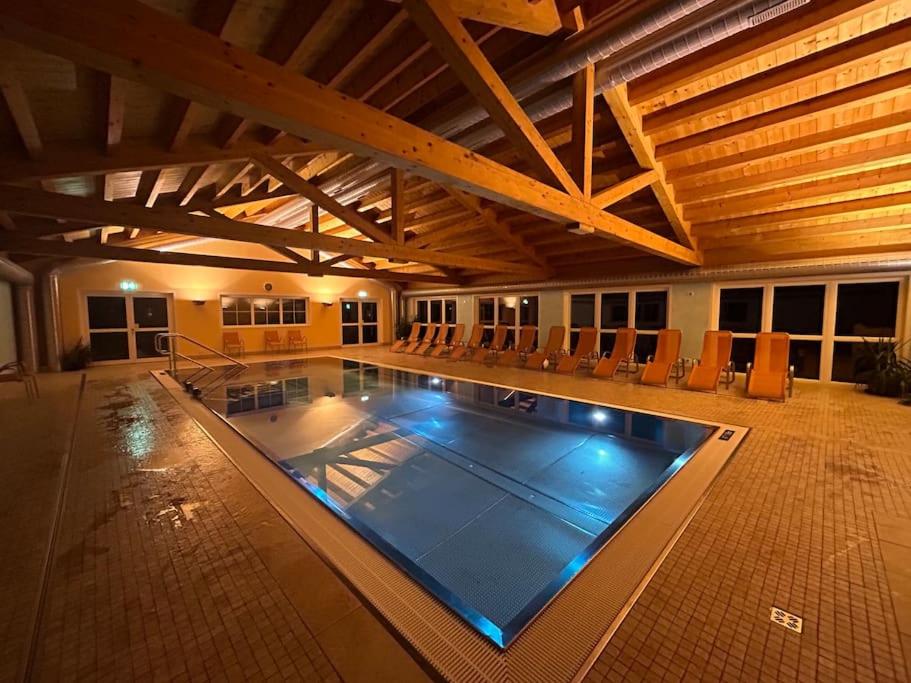a large swimming pool in a building with a wooden ceiling at Chalet im Wanderparadies in Annaberg im Lammertal