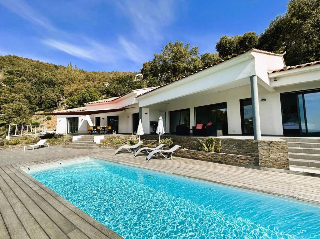une maison avec piscine à côté d'une maison dans l'établissement Villa Eden pour 8 personnes climatisée avec piscine chauffée et vue mer à La Londe-les-Maures, à La Londe-les-Maures