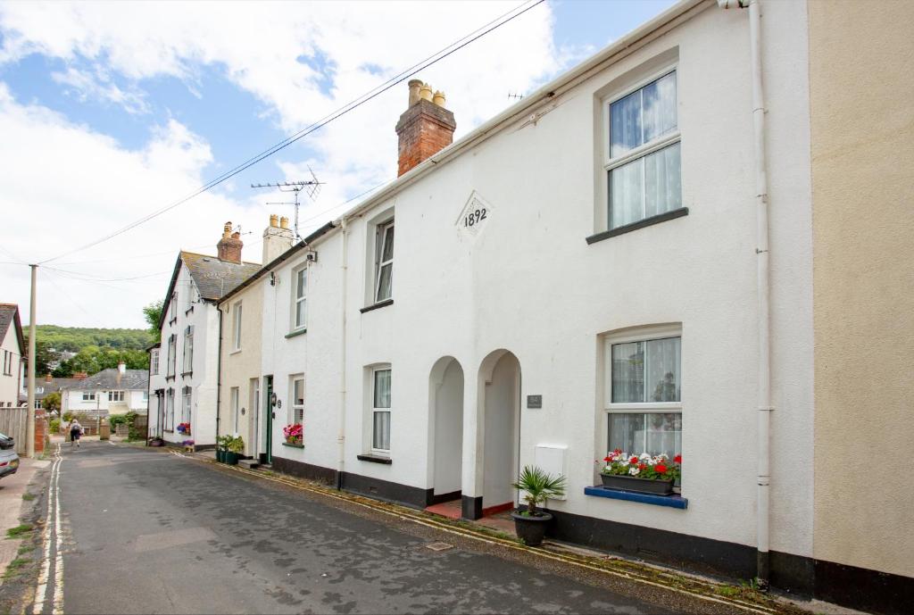eine Straße in einer kleinen Stadt mit weißen Häusern in der Unterkunft Salty Cottage in Sidmouth