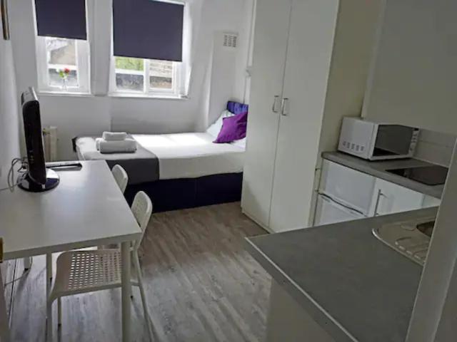 ロンドンにあるStudio Flat By Hyde Park - 21の小さなベッドとキッチンが備わる小さな客室です。