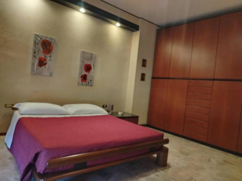 een slaapkamer met een bed en een houten kast bij L'attico di Ovidio 2 in Sulmona