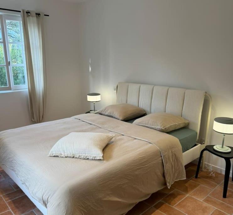 a large white bed with two pillows and two lamps at Appartement Centre Ville in Porto-Vecchio