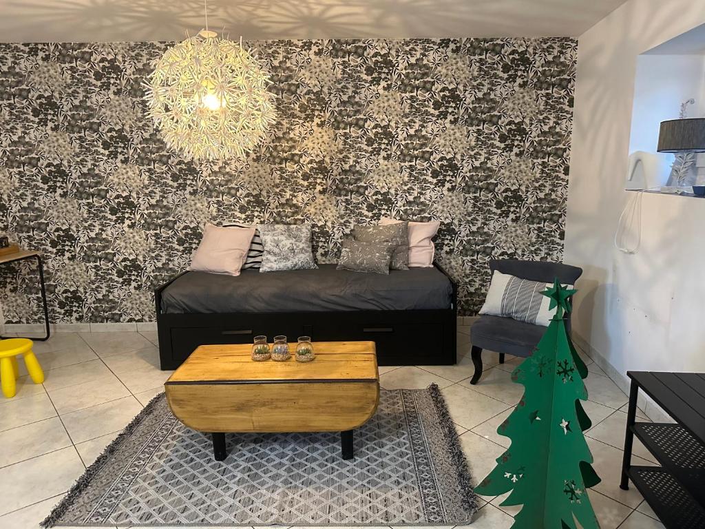 a living room with a couch and a christmas tree at Petite maison sur ferme 5min de la plage idéal professionnel in Trémel