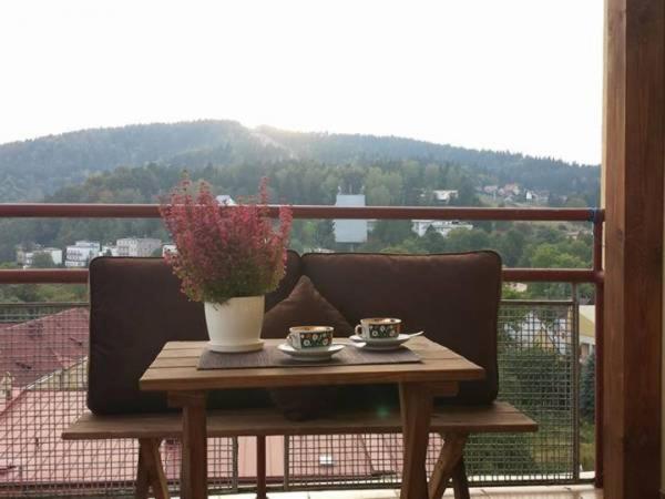 a table with two cups and a vase on a balcony at Willa Lena in Krynica Zdrój