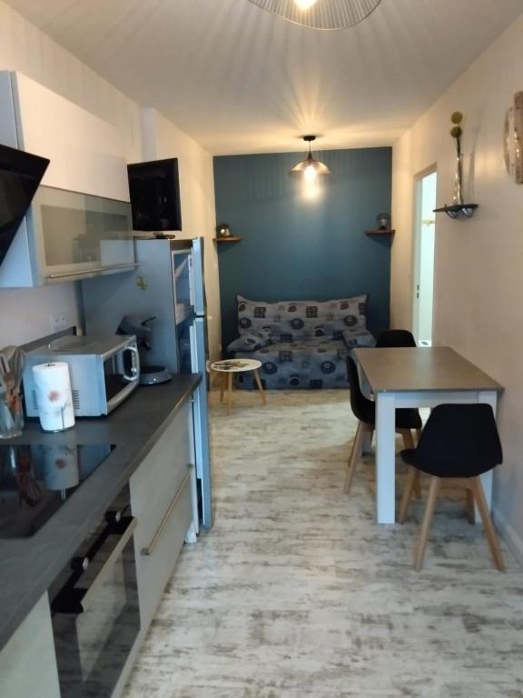 une cuisine et un salon avec une table et un canapé dans l'établissement Le thermal, à La Bourboule