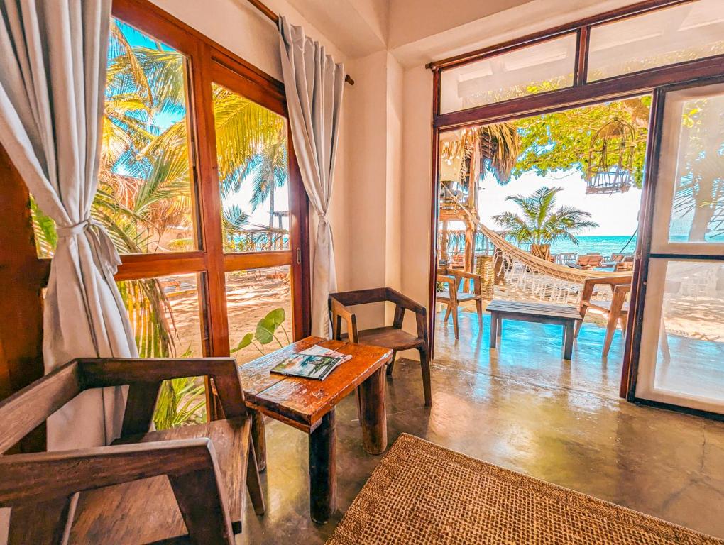a living room with a table and chairs and windows at Casa Coraje in Palomino