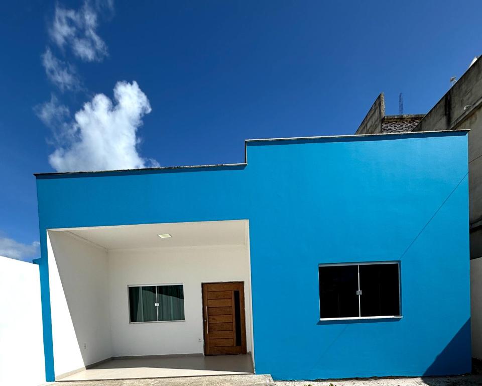 een blauw-wit gebouw met een deur bij Casa de Praia Temporada in Prado