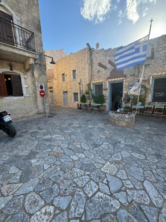 a stone courtyard with a flag on a building at Mani Spot center in Areopoli