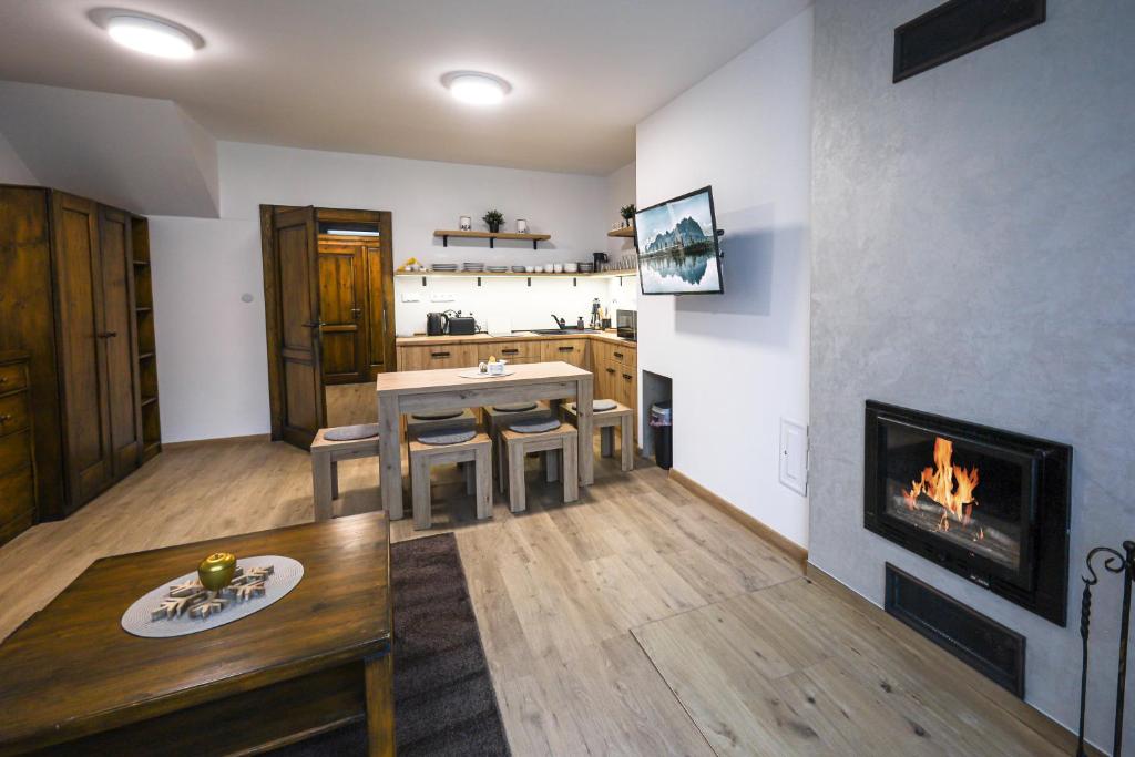 a living room with a table and a fireplace at Apartmán Vločka Tatranská Lomnica in Tatranská Lomnica