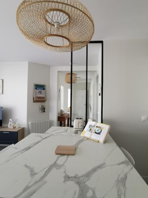 - une chambre avec un grand lit et un lustre dans l'établissement Appartement de standing Pontaillac, à Royan