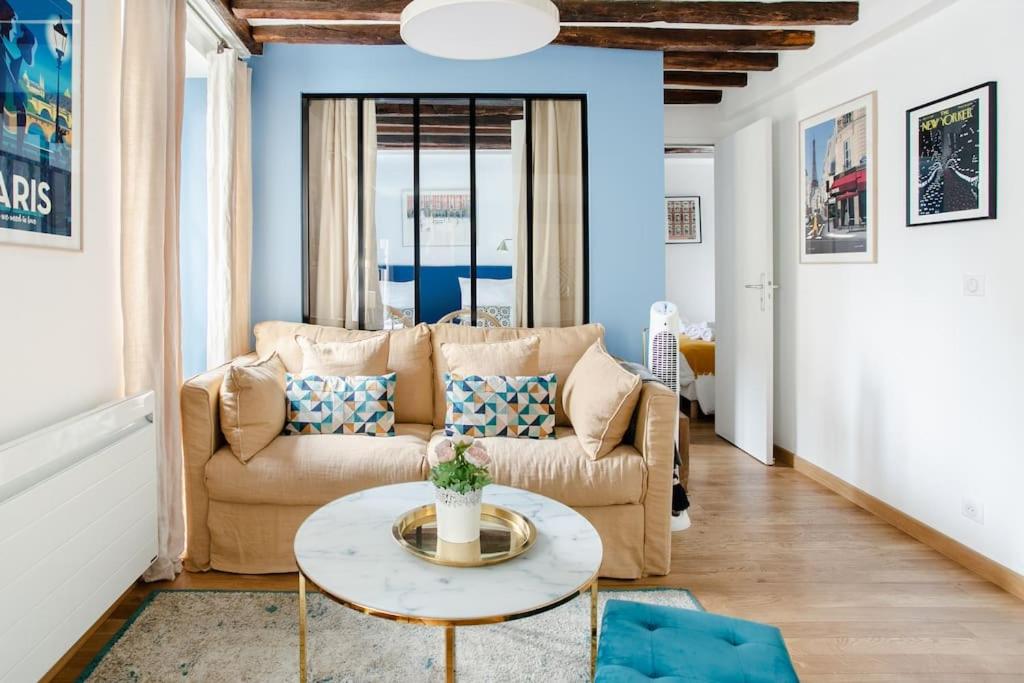 un salon avec un canapé et une table dans l'établissement Marais2 Place des Vosges peaceful air-conditioned, à Paris