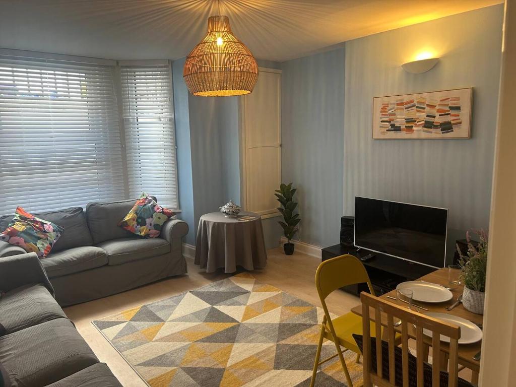 a living room with a couch and a table at Charming Seafront Retreat in Broadstairs