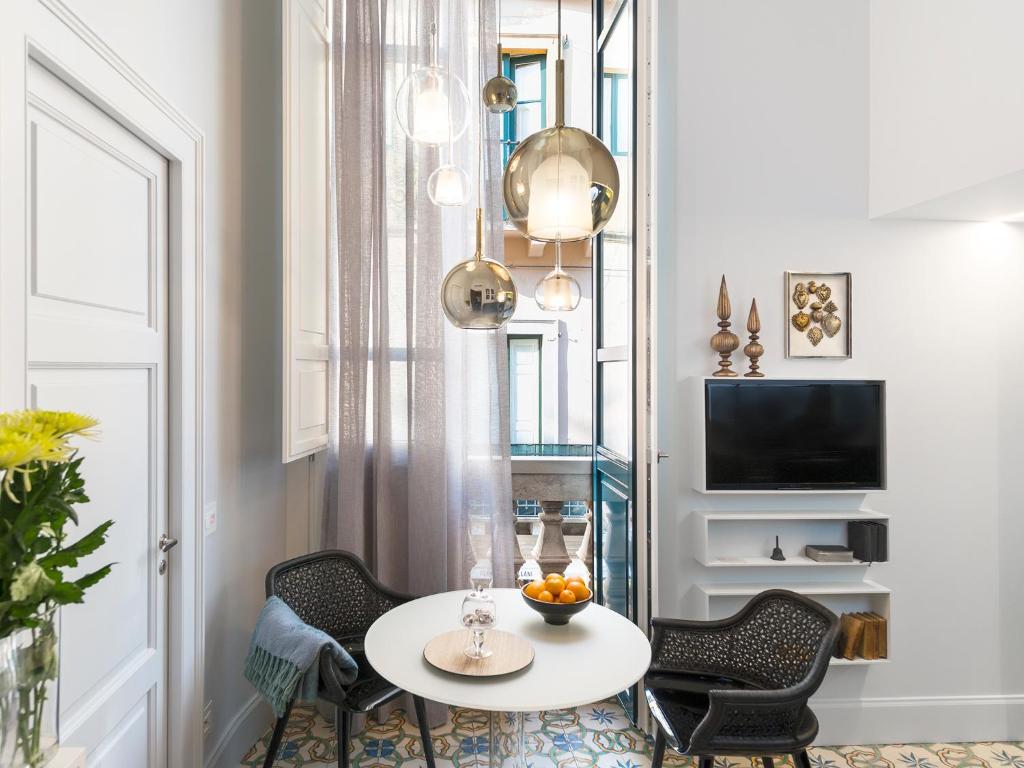 タオルミーナにあるVarò Apartmentのテーブル、椅子、テレビが備わる客室です。