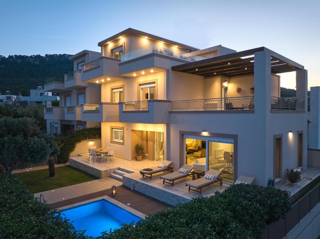 a large house with a swimming pool in front of it at Chrissiida Villa in Ialyssos