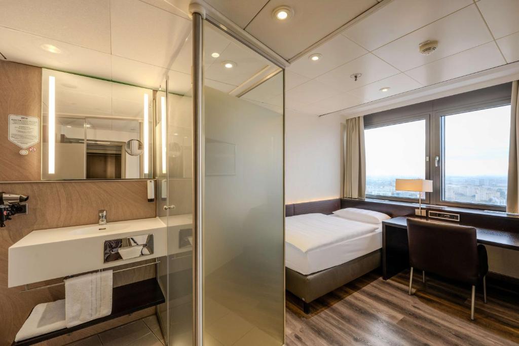 bagno con letto, lavandino e specchio di Park Inn by Radisson Berlin Alexanderplatz a Berlino