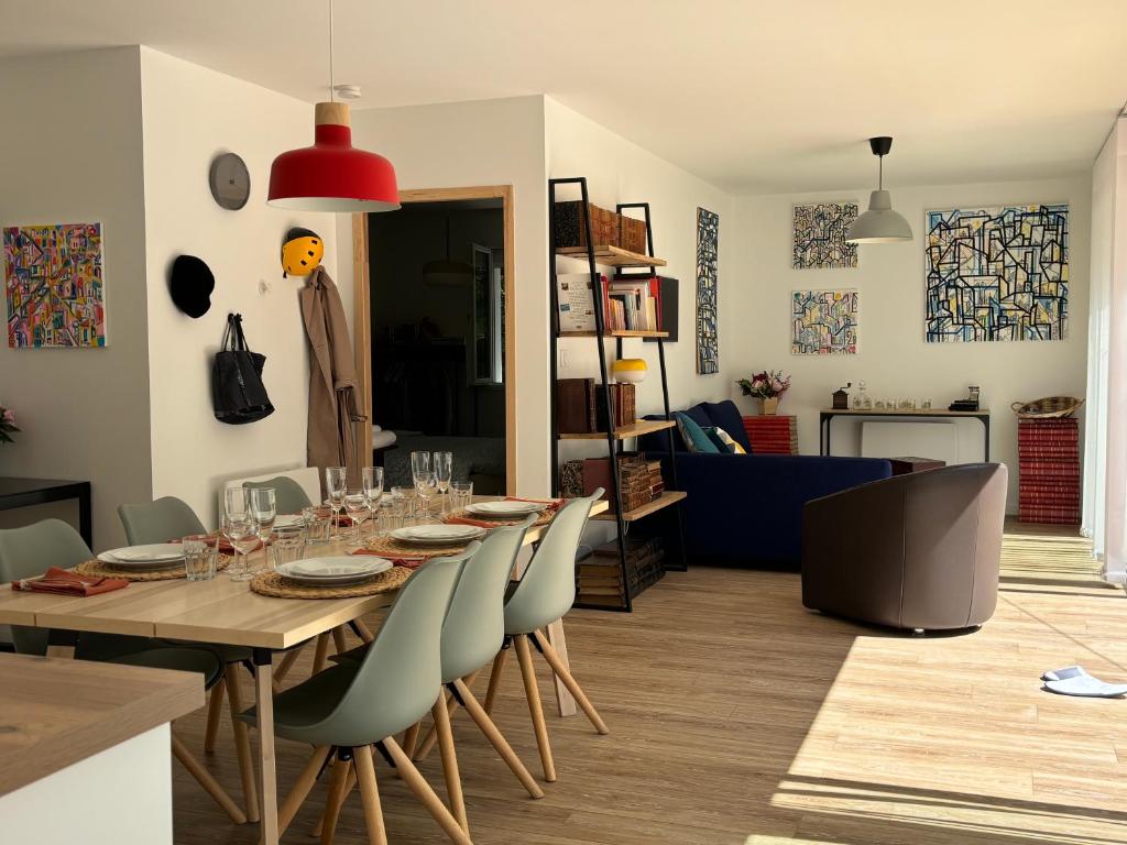 une salle à manger et un salon avec une table et des chaises dans l'établissement Maison à 10 min d'Angers, à Mûrs-Érigné