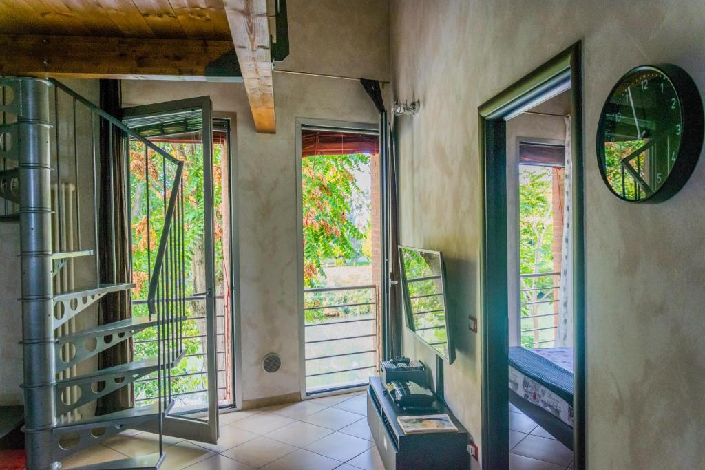 Habitación con 3 ventanas y escalera. en Un Nido sul Fiume, en Ferrara