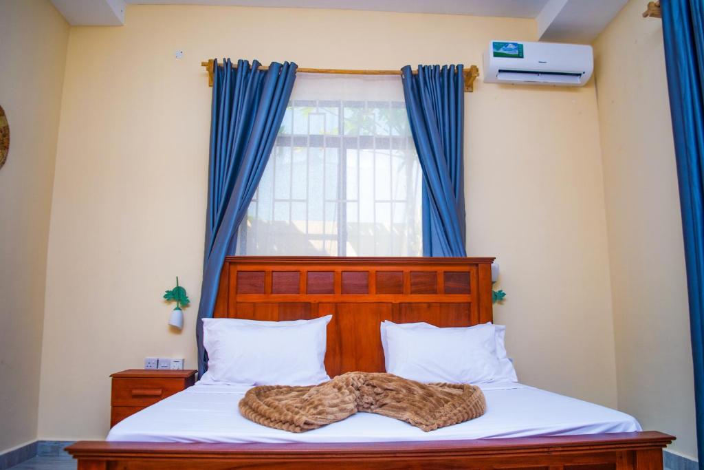 un letto con una coperta leopardata sopra di Makazi Garden Villas a Zanzibar City