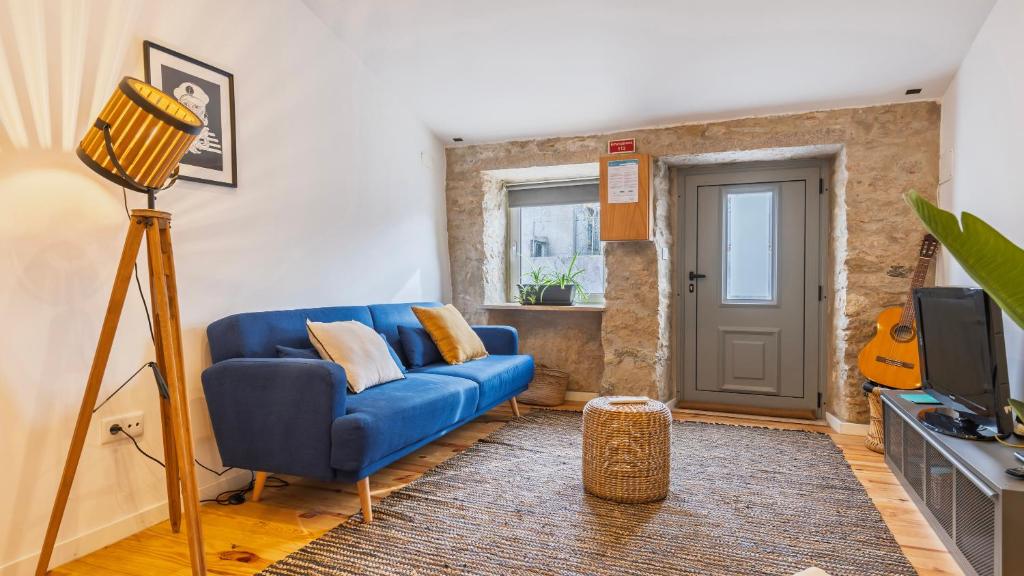 a living room with a blue couch and a tv at Pátio Vilareto - Villa Fernanda in São Domingos de Rana